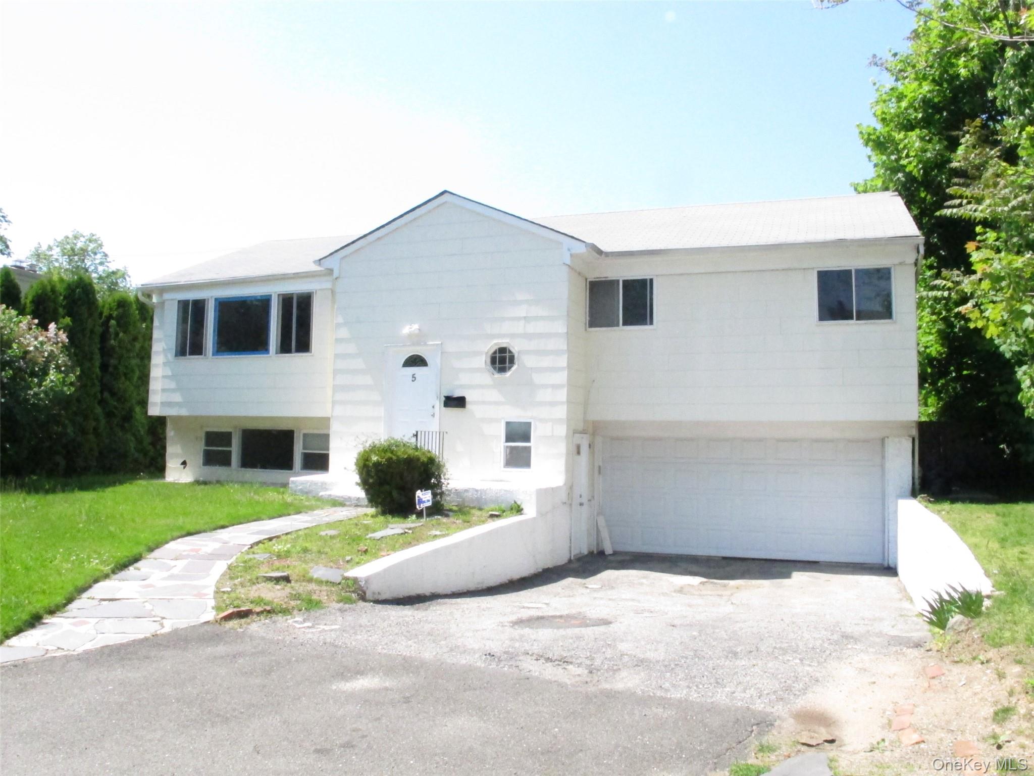 5 Elm Street Great Neck, NY 11021 - Photo 16 of 17 a front view of a house with a yard and garage