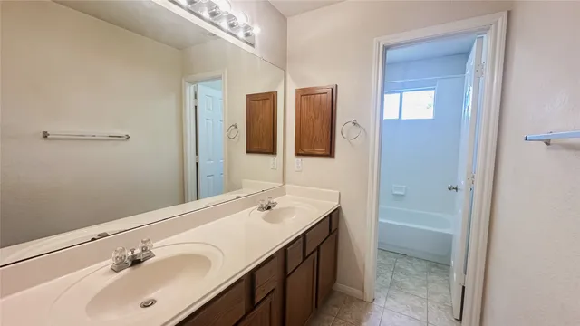 an empty room with chandelier fan and windows