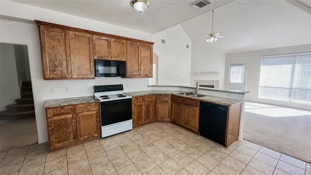 a kitchen with granite countertop a stove top oven sink and cabinets