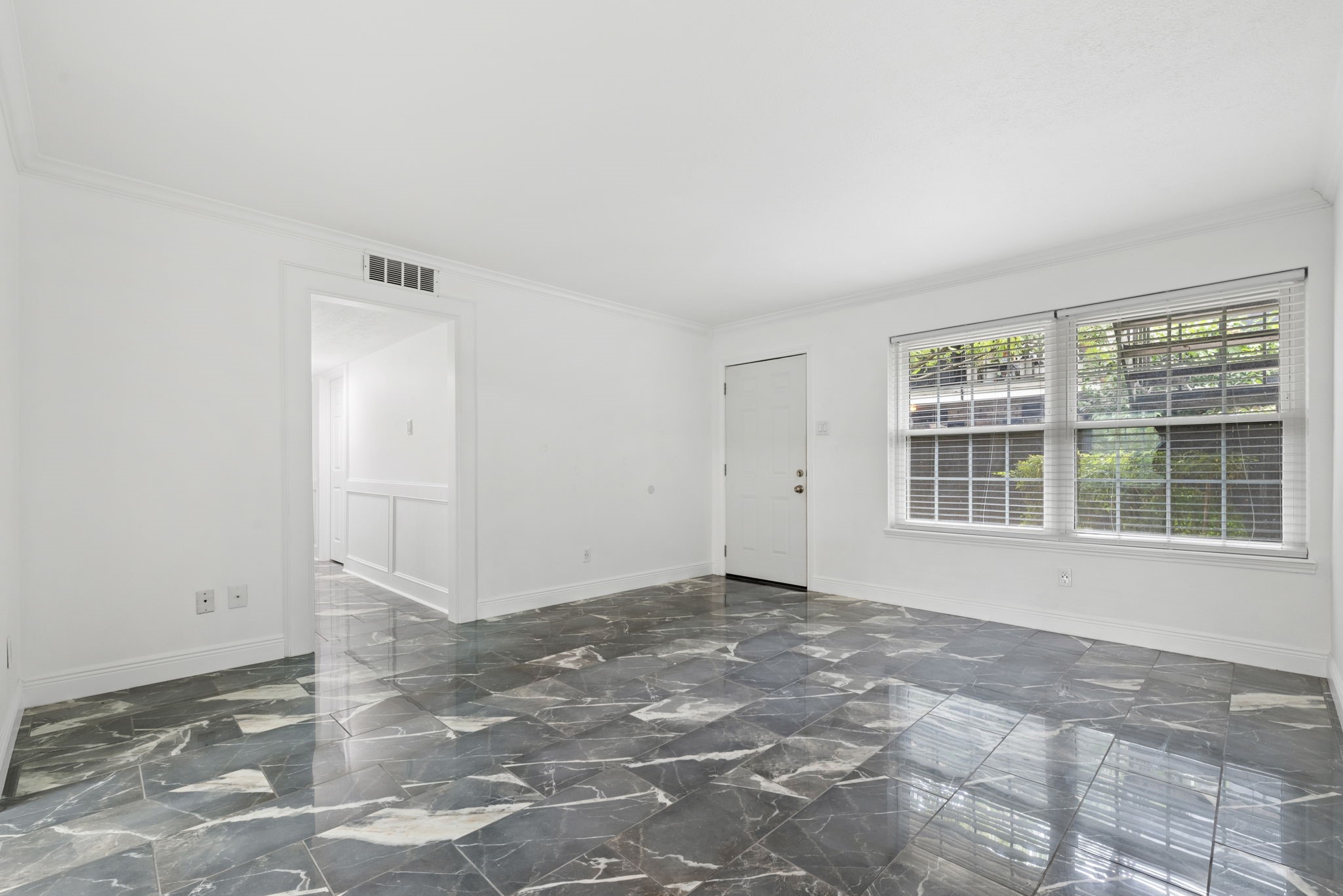 7900 Westheimer Road, Unit 121 Houston, TX 77063 - Photo 9 of 23 Spacious living area with elegant marble flooring, abundant natural light from large windows, and a clean, modern design.