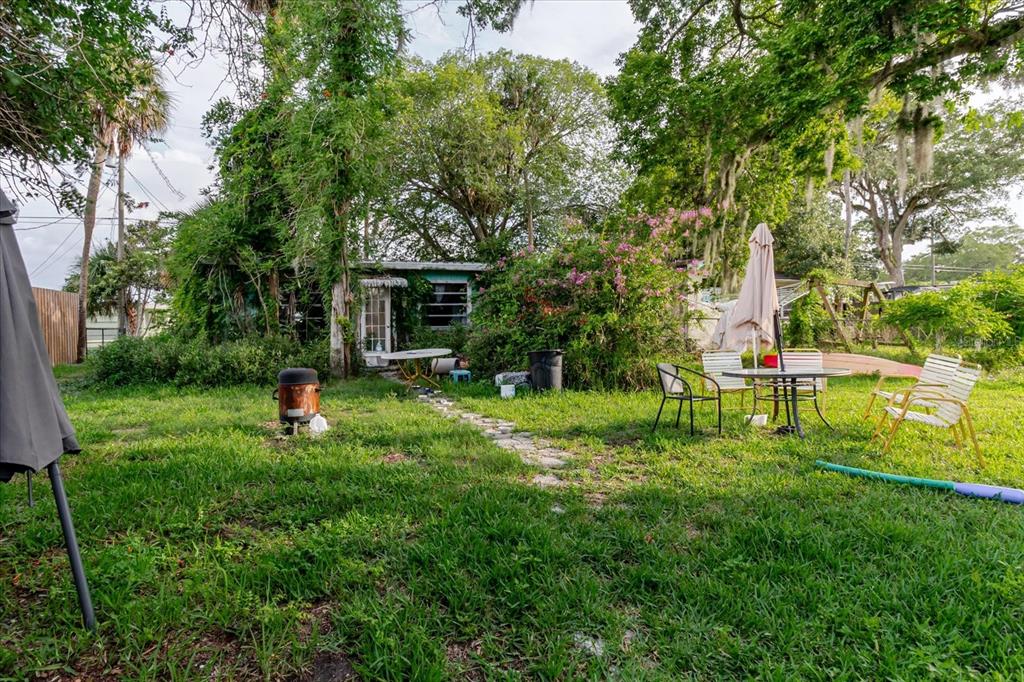 5323 Circle Drive Weeki Wachee, FL 34607 - Photo 58 of 77 a view of backyard with table and chairs and potted plants and large trees