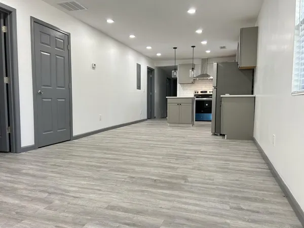 a kitchen with stainless steel appliances granite countertop a refrigerator a sink dishwasher a stove with white cabinets and wooden floor