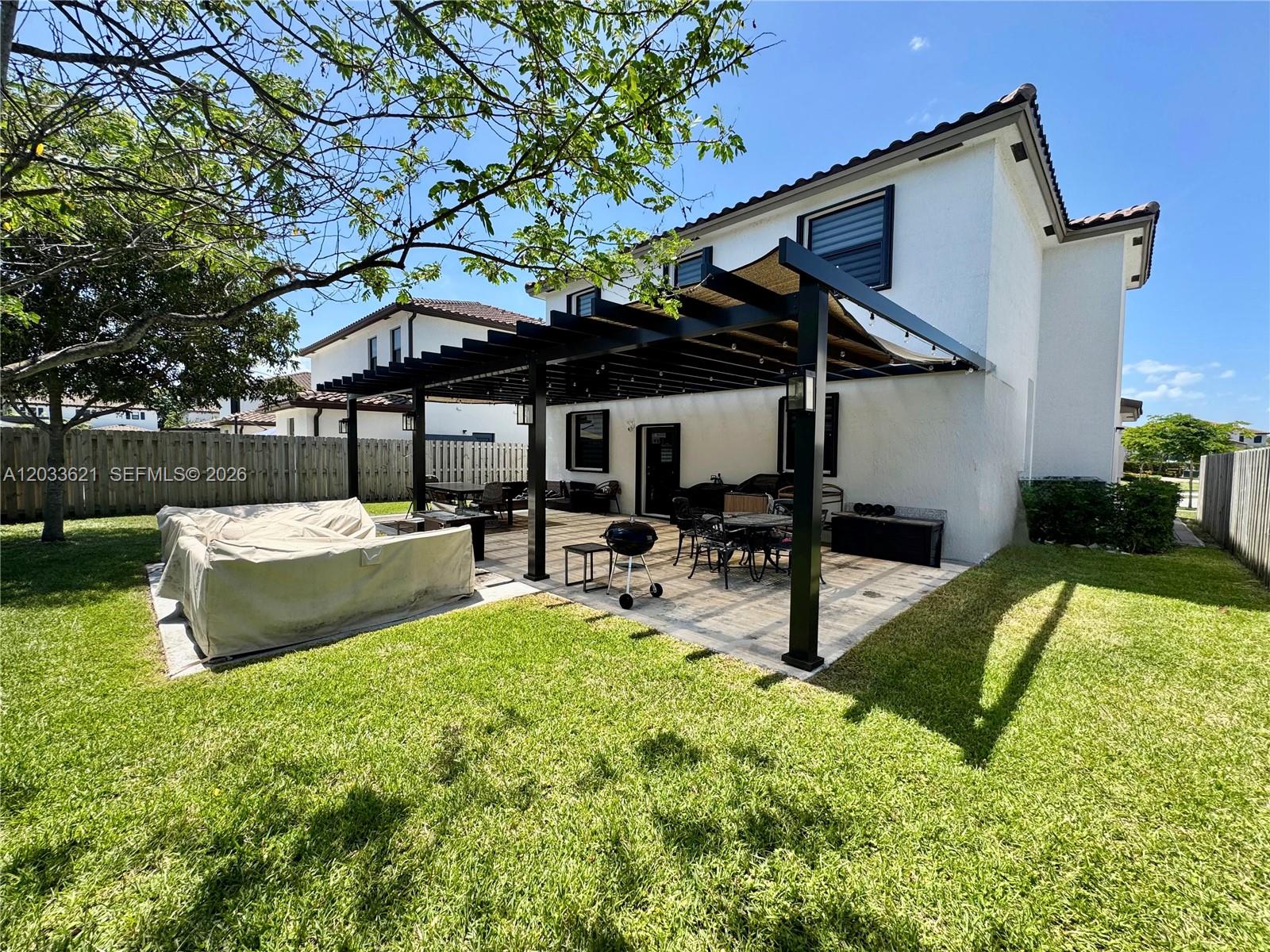 11942 Southwest 243rd Street Homestead, FL 33032 - Photo 34 of 50 a view of a patio with table and chairs under an umbrella