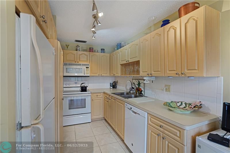 8625 Boca Drive, Unit 12 Boca Raton, FL 33433 - Photo 5 of 42 a kitchen with a sink a stove and cabinets