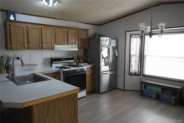 a kitchen that has a sink stainless steel appliances a window and a counter top space