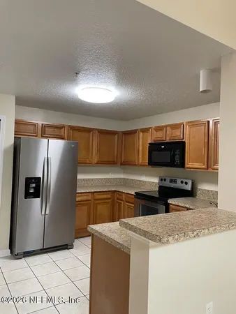 a kitchen with stainless steel appliances granite countertop a refrigerator a stove and a sink