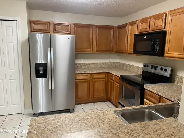 a kitchen with stainless steel appliances granite countertop a refrigerator stove and sink