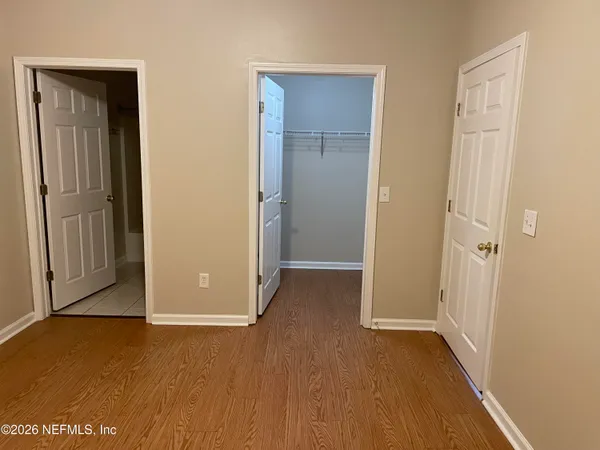 an empty room with closet and windows