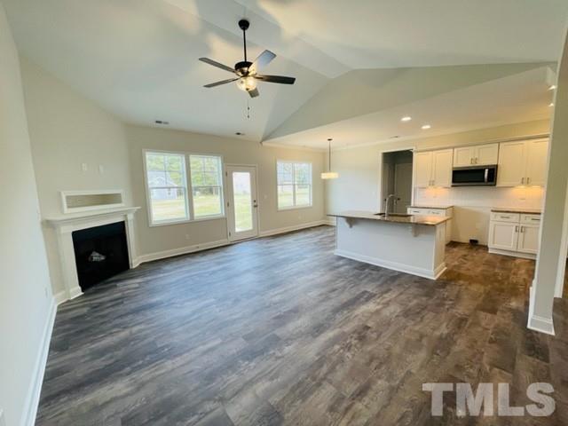 5770 Stott Street Bailey, NC 27807 - Photo 8 of 16 a view of a kitchen with a stove cabinets wooden floor and a fireplace