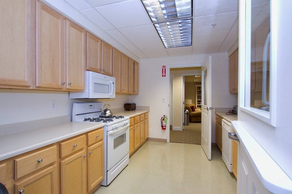 38 Village Road, Unit 615 Middleton, MA 01949 - Photo 20 of 23 a kitchen with stainless steel appliances a white cabinets and wooden floor
