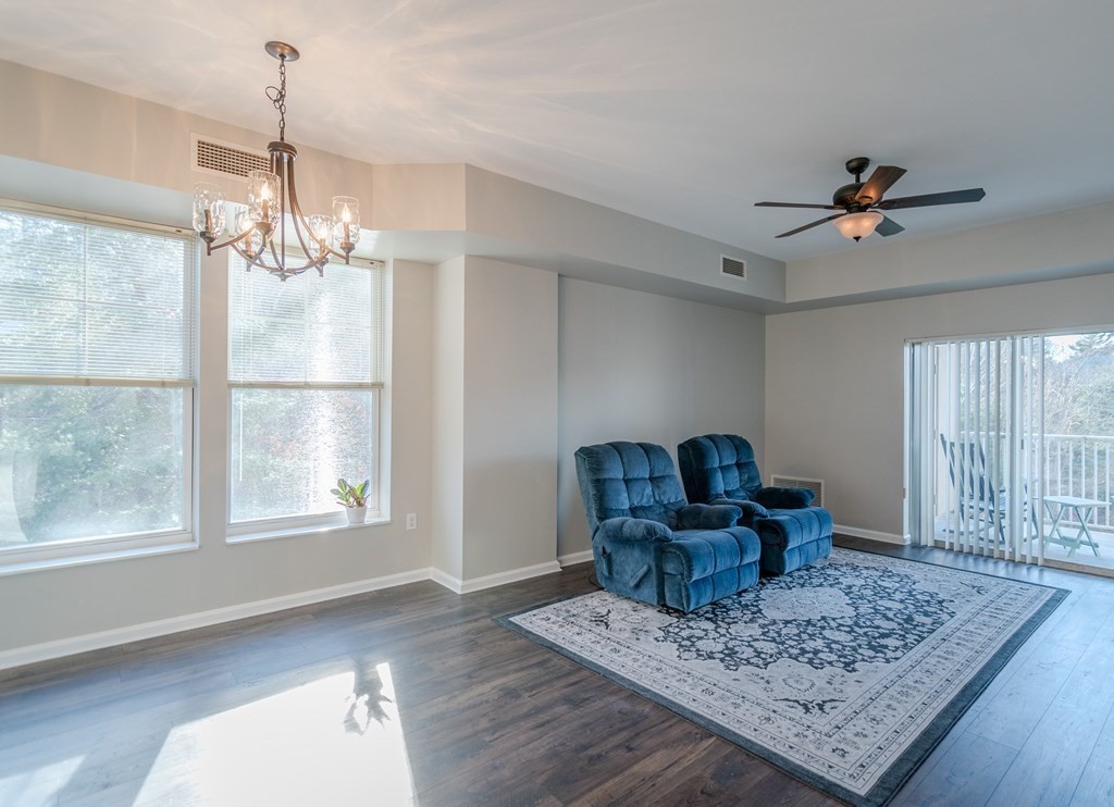 38 Village Road, Unit 615 Middleton, MA 01949 - Photo 6 of 23 a living room with furniture and a chandelier