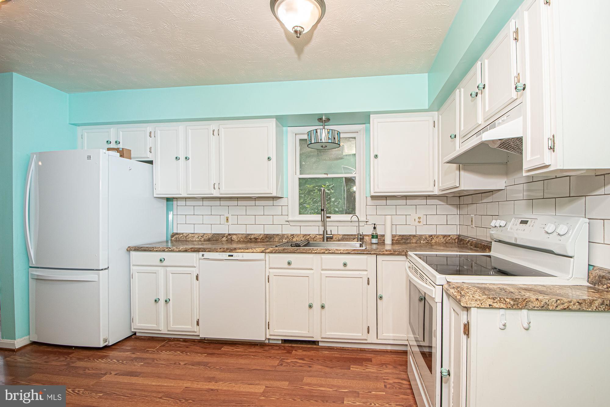 302 Parkside Road Linden, VA 22642 - Photo 7 of 30 a kitchen with a sink a refrigerator a stove and cabinets