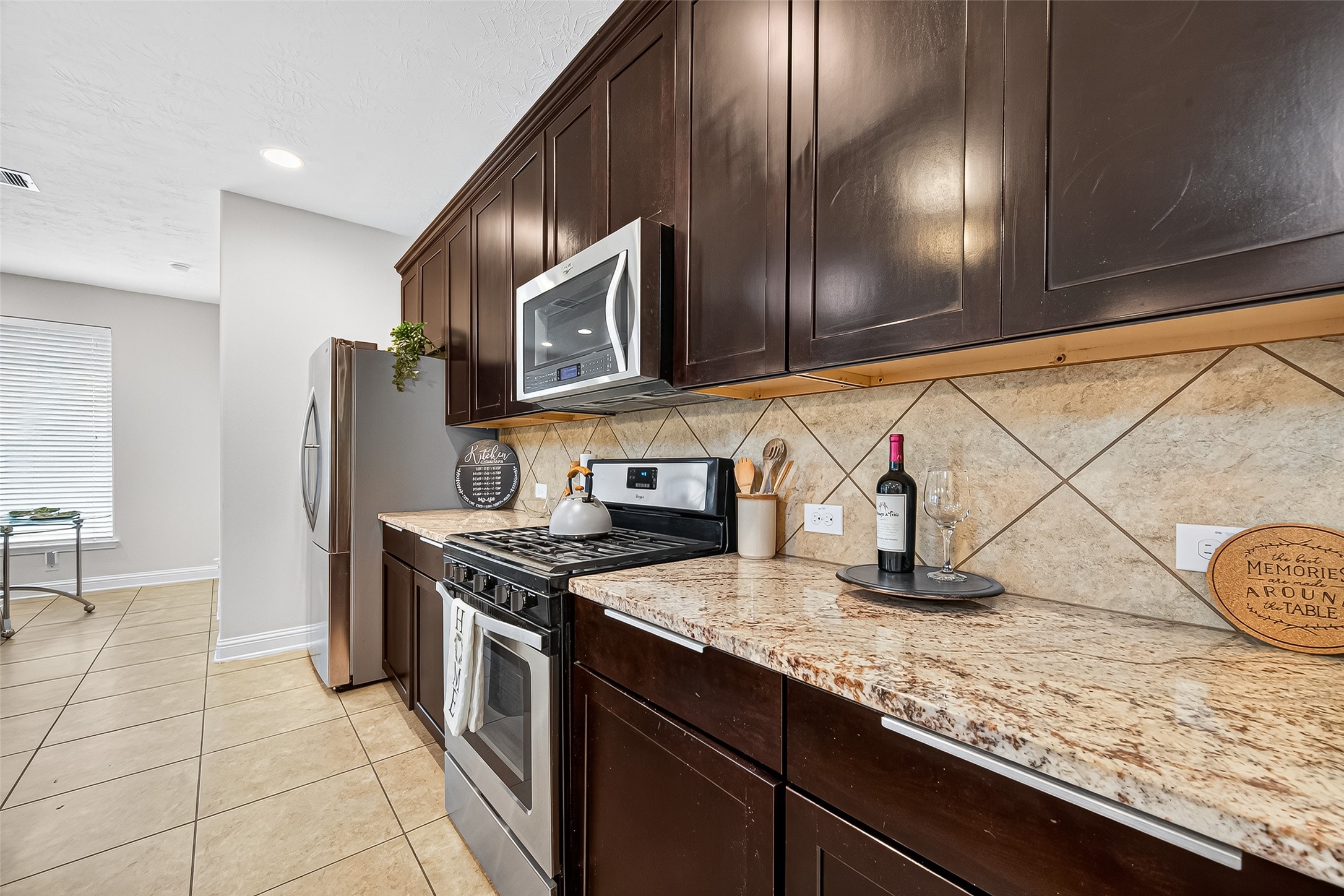 8107 Lockridge Terrace Lane Cypress, TX 77433 - Photo 18 of 50 This close-up view highlights the kitchen’s impeccable craftsmanship—glistening granite countertops, a sleek gas range, and richly stained cabinetry that adds warmth and elegance. Whether you're prepping weeknight dinners or hosting holiday feasts, this well-appointed space offers beauty, functionality, and lasting impressions.