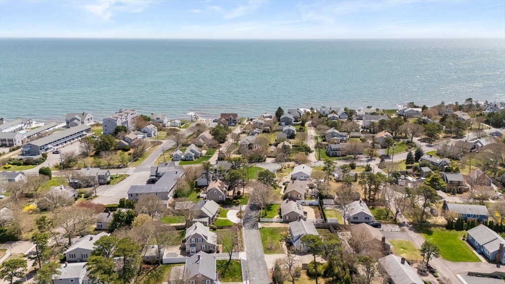 an aerial view of a city with ocean view in back