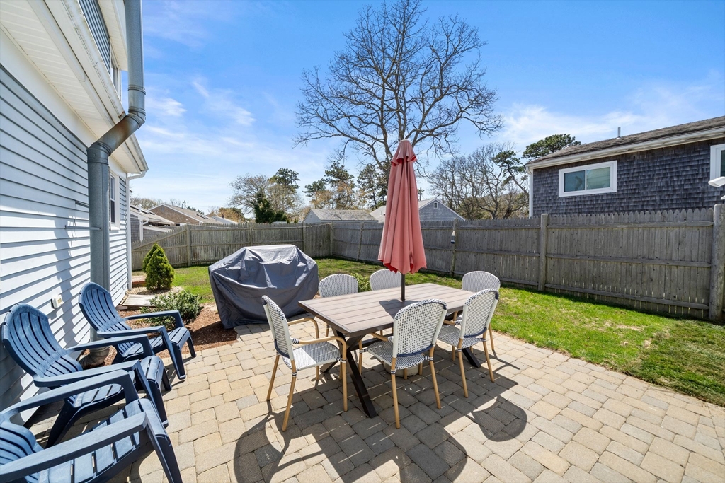 13 Hamilton Road Dennis, MA 02639 - Photo 36 of 40 a view of a patio with a table and chairs and a barbeque