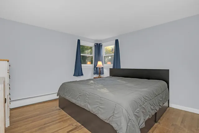 a bedroom with a bed and wooden floor