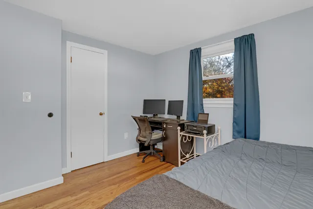 a view of a workspace with furniture and wooden floor