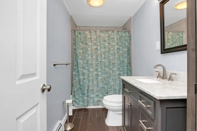 a bathroom with a granite countertop sink toilet and shower