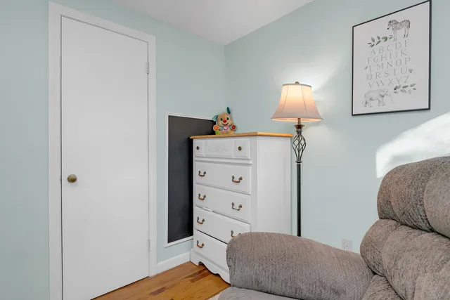 a bedroom with a bed and a lamp on the dresser