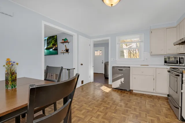 a kitchen with a refrigerator a stove a sink dishwasher and white cabinets with wooden floor