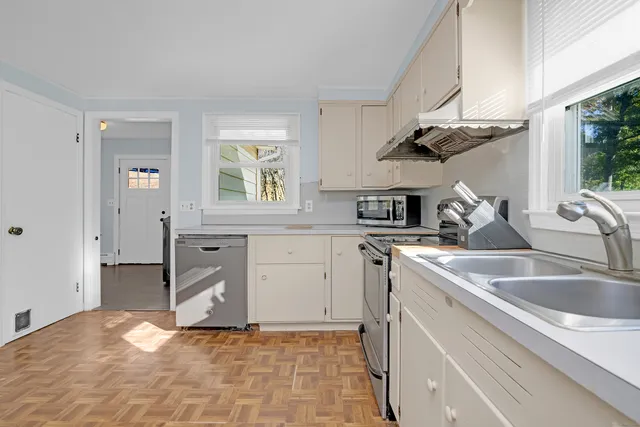 a kitchen with stainless steel appliances white cabinets and a stove top oven