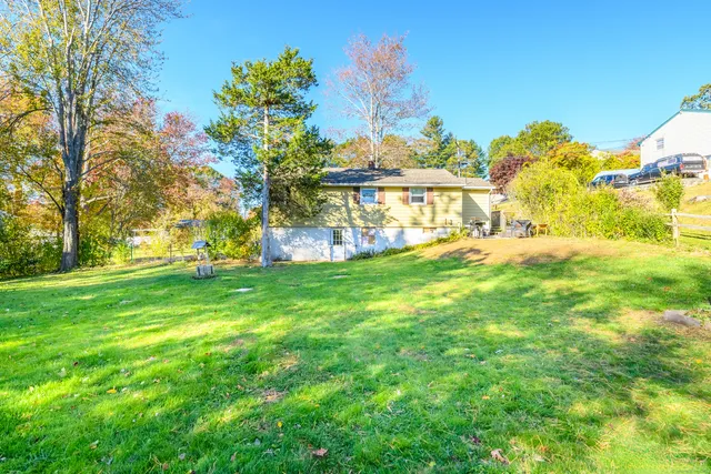 a view of a house with a big yard and palm trees