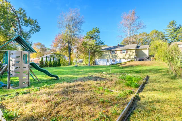 a view of yard with swimming pool and green space