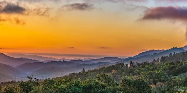 an aerial view of mountain with an ocean