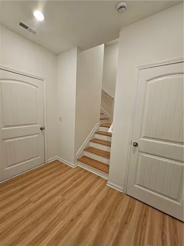 a view of a room with wooden floor and white doors