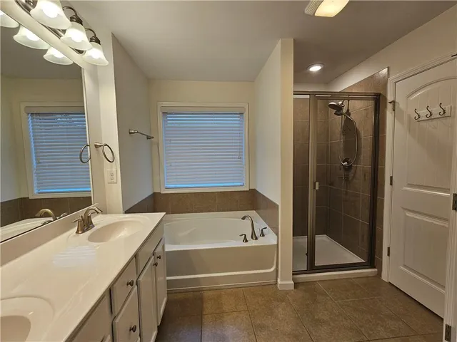 a bathroom with a tub sink and mirror