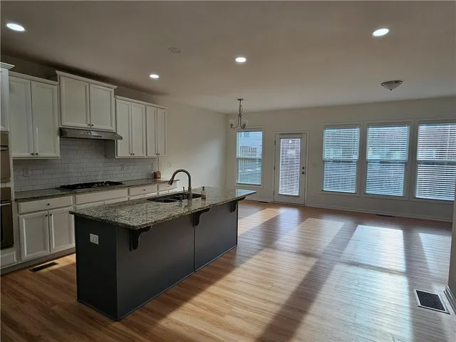 a kitchen with stainless steel appliances granite countertop a stove a sink and a refrigerator