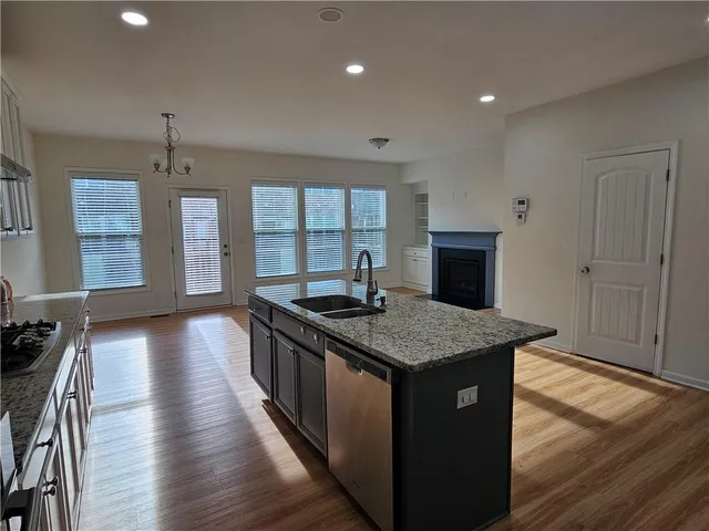 a kitchen with stainless steel appliances granite countertop a stove and a wooden floors