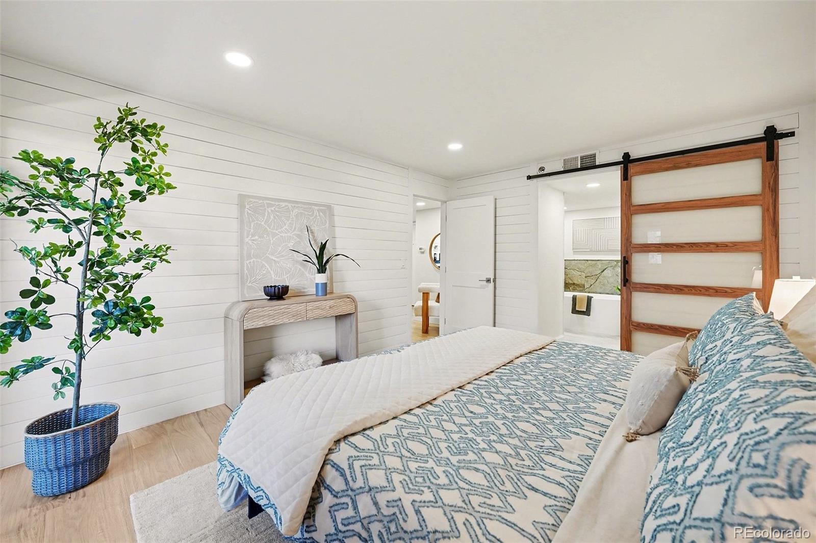 350 Detroit Street, Unit 209 Denver, CO 80206 - Photo 11 of 23 a spacious bedroom with a bed and a potted plant