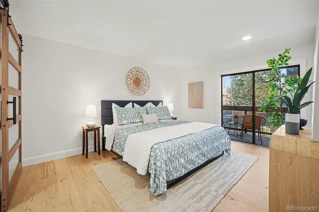 a bedroom with a large bed potted plant and a large window