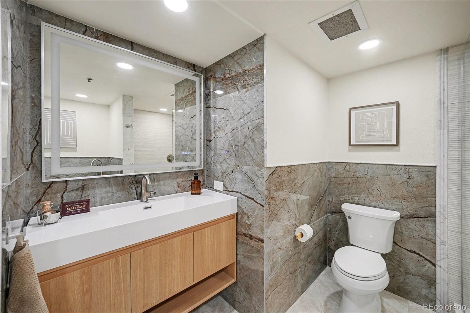 350 Detroit Street, Unit 209 Denver, CO 80206 - Photo 14 of 23 a bathroom with a sink a toilet and a mirror