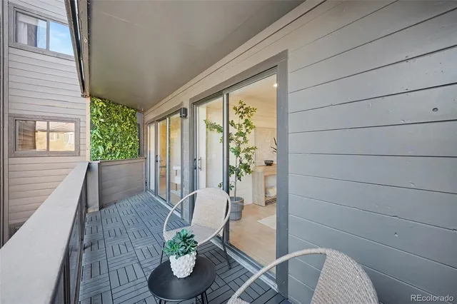 a view of balcony with chairs and wooden fence
