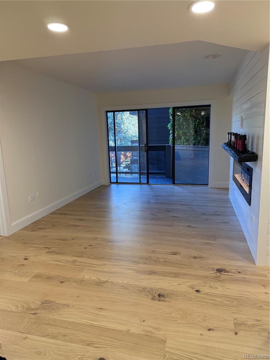 350 Detroit Street, Unit 209 Denver, CO 80206 - Photo 3 of 12 a view of an empty room with a window and wooden floor