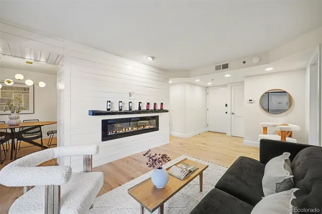 a living room with furniture and a dining table with wooden floor