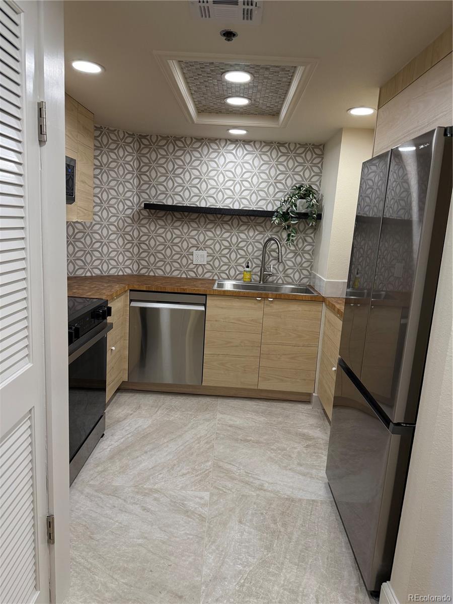350 Detroit Street, Unit 209 Denver, CO 80206 - Photo 4 of 12 a kitchen with stainless steel appliances granite countertop a sink a stove and a refrigerator