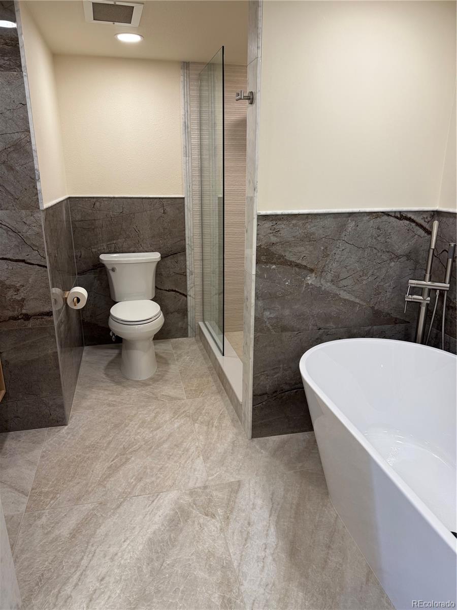 350 Detroit Street, Unit 209 Denver, CO 80206 - Photo 8 of 12 a white bath tub sitting in a bathroom