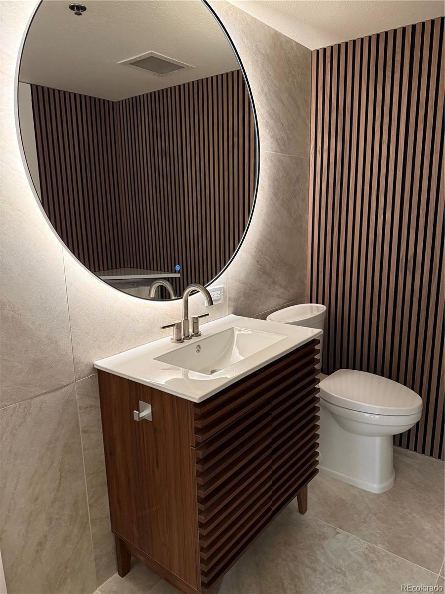 350 Detroit Street, Unit 209 Denver, CO 80206 - Photo 10 of 12 a bathroom with a sink a toilet and mirror