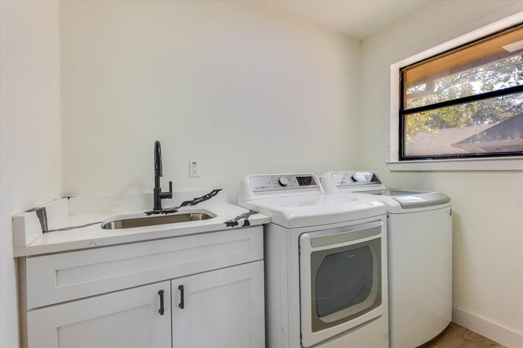 8105 Ravenswood Road Granbury, TX 76049 - Photo 15 of 28 Laundry area featuring a utility sink with a matte black faucet, white cabinetry, and a window