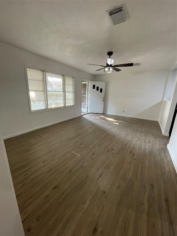 1119 Tobola Street Rosenberg, TX 77471 - Photo 4 of 14 an empty room with wooden floor ceiling fan and windows