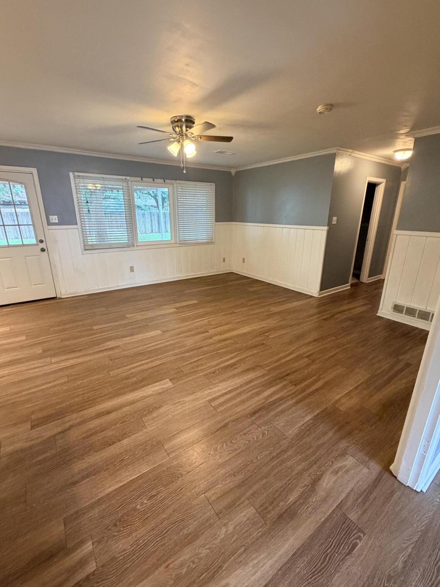 3814 27th Street Lubbock, TX 79410 - Photo 7 of 24 a view of an empty room with wooden floor and a window