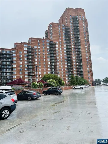 a view of a buildings and cars parked in front of it