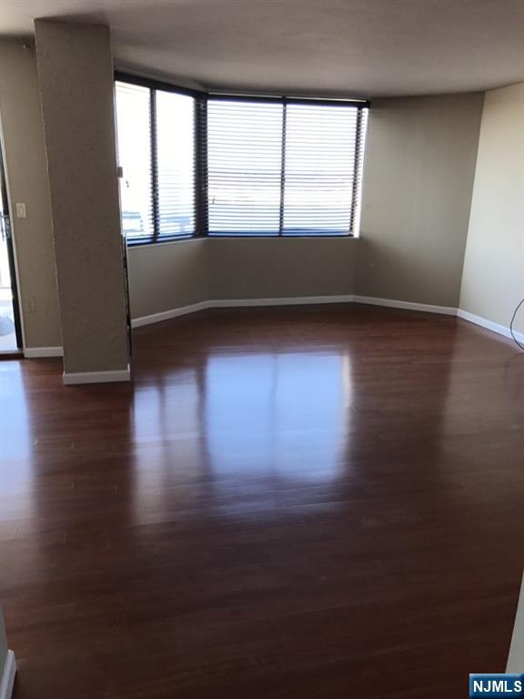 1040 Harmon Cove Tower, Unit 1040 Secaucus, NJ 07094 - Photo 9 of 15 an empty room with wooden floor and windows