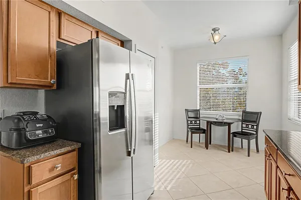 a kitchen with granite countertop a refrigerator and a table