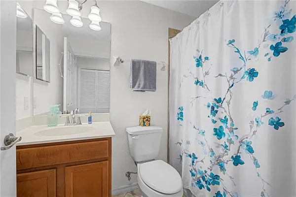 a bathroom with a sink a toilet and a shower curtain