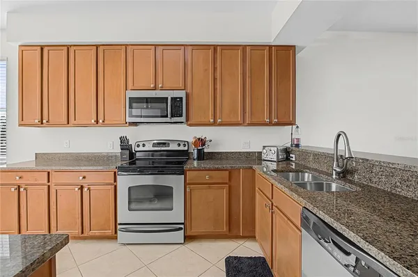 a kitchen with granite countertop a stove sink and cabinets