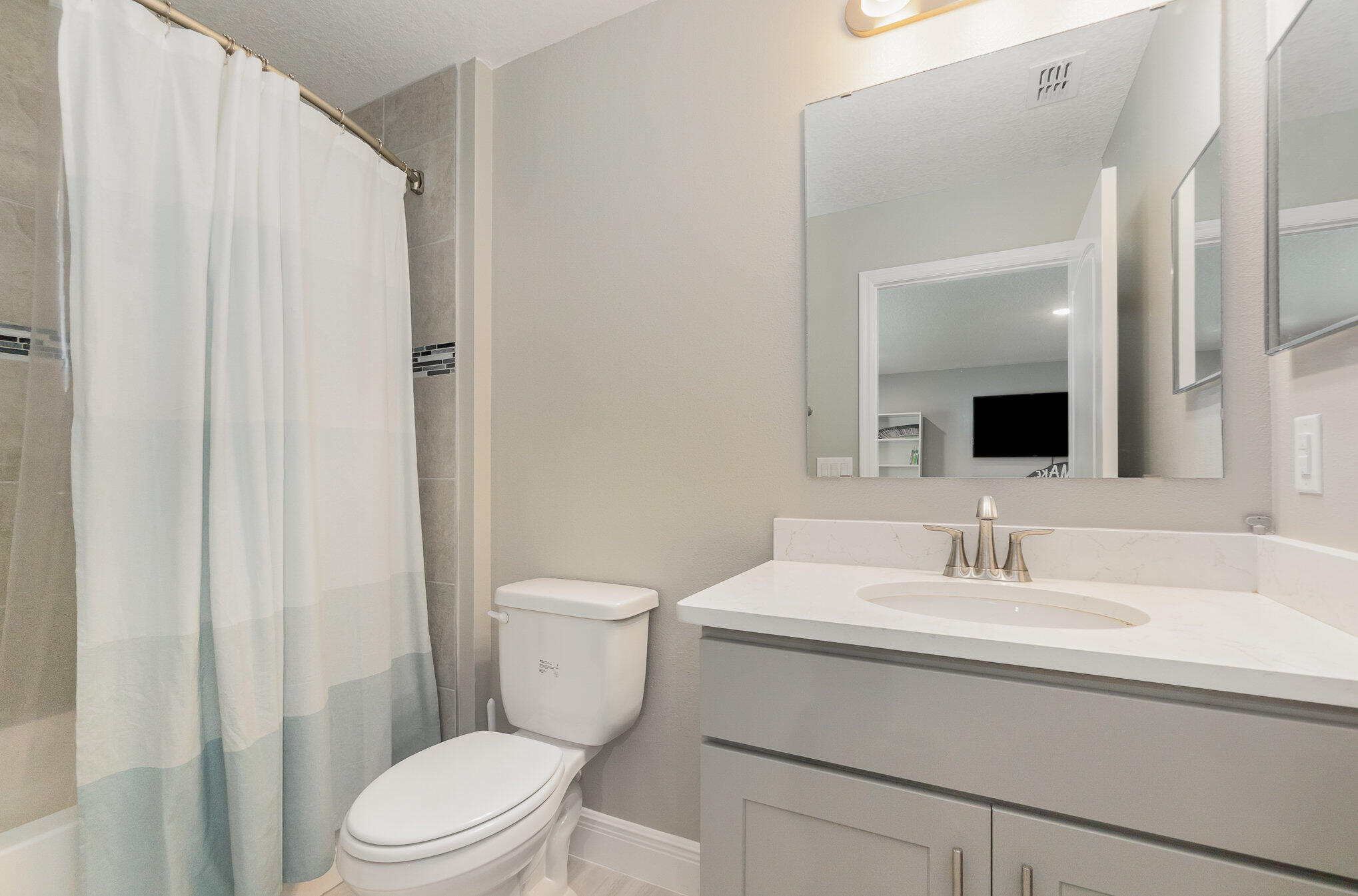 1780 Indria Lane Malabar, FL 32950 - Photo 28 of 35 a bathroom with a sink a toilet a mirror and shower curtain